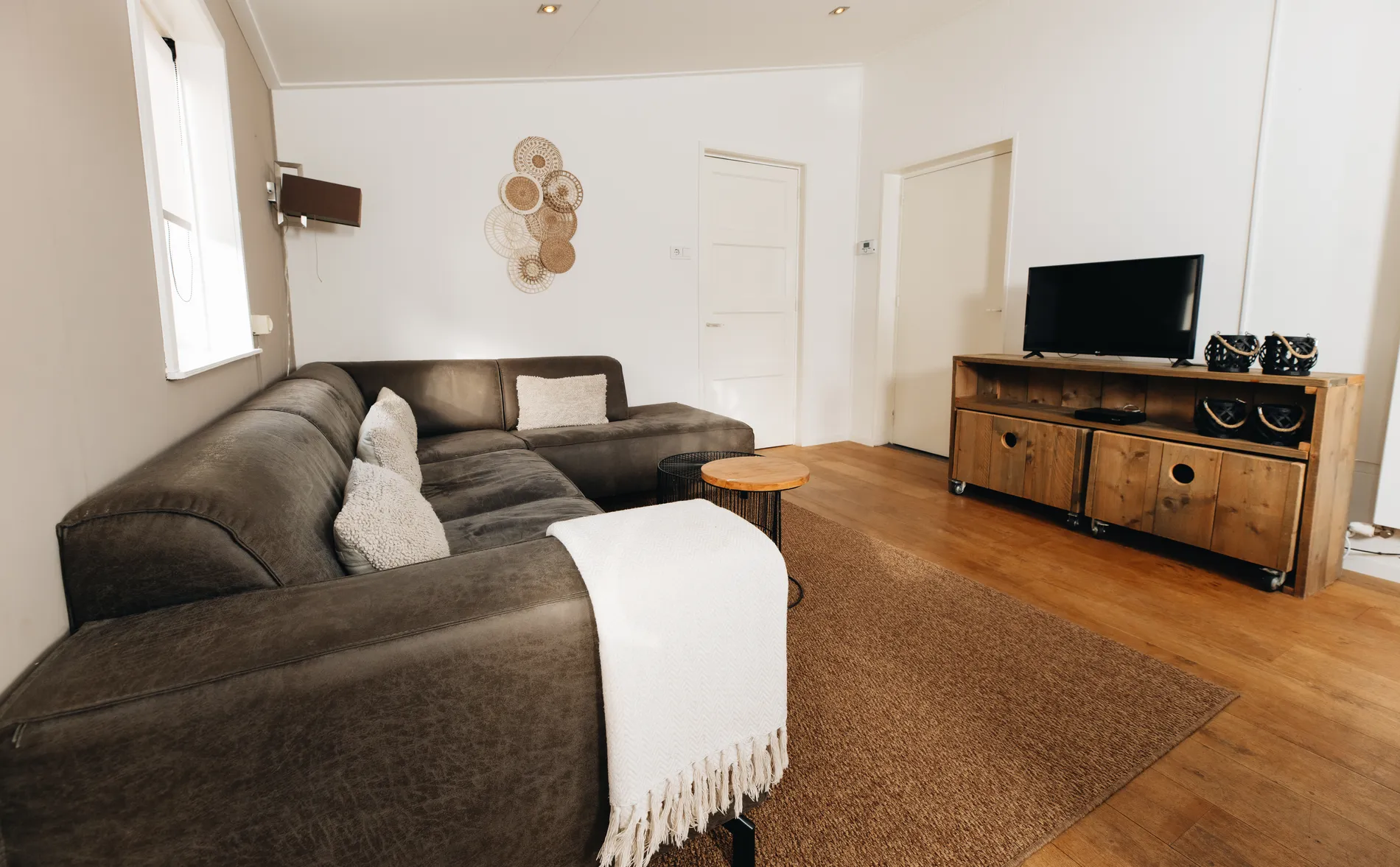 Detail van de zithoek in de luxe 6-persoons vakantiewoning met een comfortabele loungebank en houten vloer.